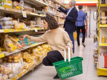 Vrouw zit op haar hurken in de supermarkt